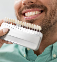 Dentist color-matching veneers to a patient’s natural teeth