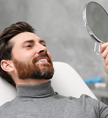 a patient checking his teeth with a mirror