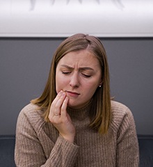 Woman in pain needing an emergency dentist