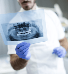 Dentist looking at dental x-ray