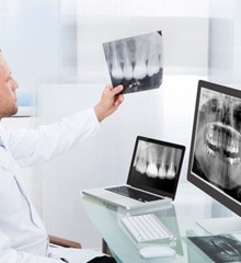 Smiling patient in a dental chair giving a thumbs up for dental implants 