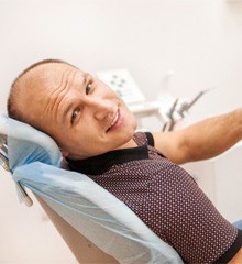 Implant dentist typing into calculator next to a model tooth 