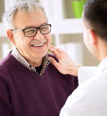 implant dentist examining a patient in dental chair 