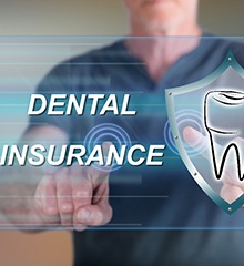 A person pointing at a screen with a digital image apperaing showing the words “Dental Insurance” and a tooth inside a shield