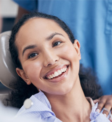 Patient smiling at dentist while sitting in treatment chair