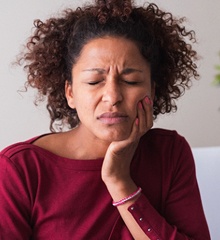 person holding their jaw in pain