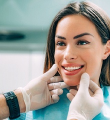 Cosmetic dentist in Farmington checking patient’s veneers