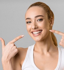 Woman pointing at her smile