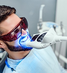 A dentist comparing a patient’s smile with a shade guide