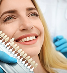 A young, bearded man undergoing an in-office teeth whitening treatment