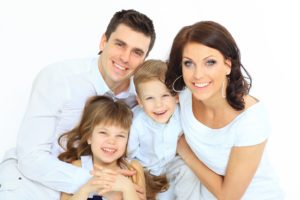 Young couple with children at family dentist in Farmington. 