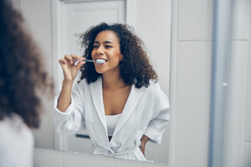 a woman brushing her teeth before breakfast in Farmington