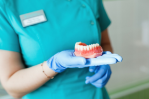 a closeup of a dentist holding dentures