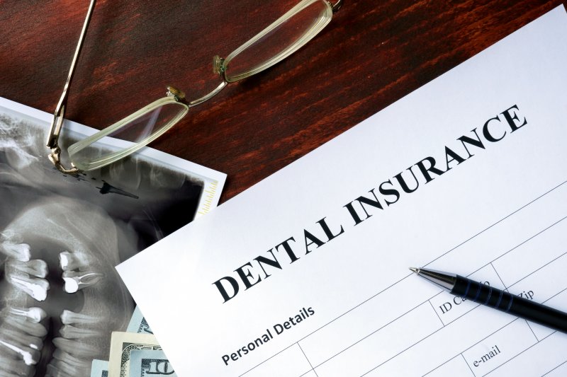 A dental insurance form sitting on a brown wooden table