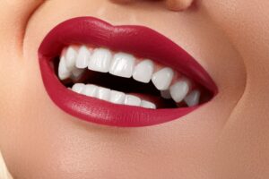 Closeup of a smiling mouth wearing red lipstick