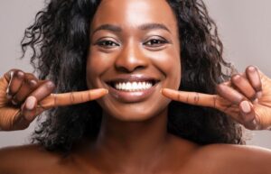 Woman with an attractive smile pointing to her teeth